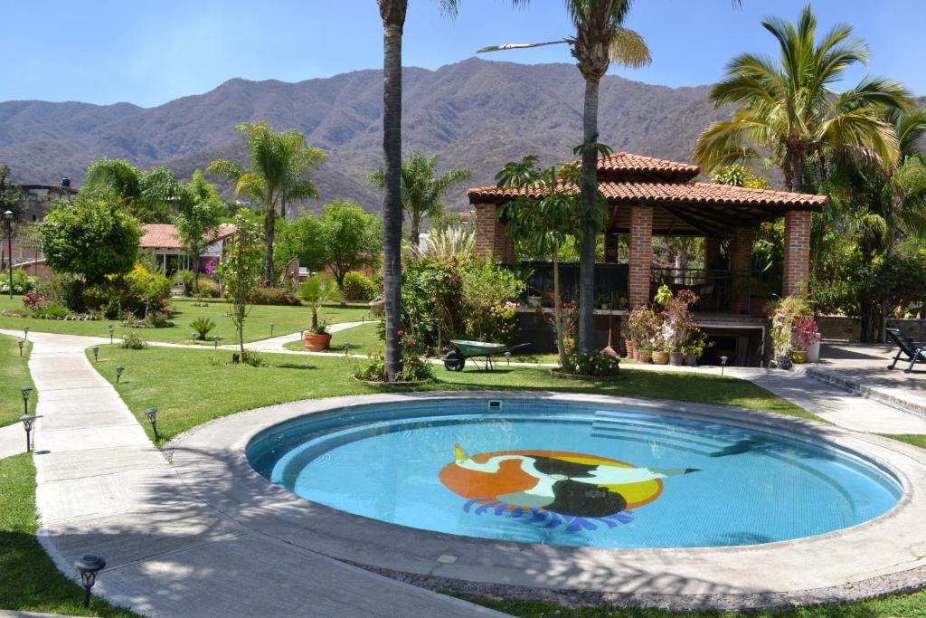 阿吉吉克La Joya del Lago的一座房子前面的游泳池,上面有绘画作品