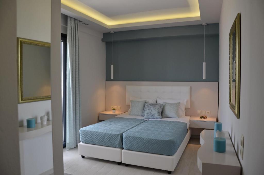 斯塔里斯Levante Sea View Studios的一间卧室配有一张带蓝色床单的大床和两张桌子。