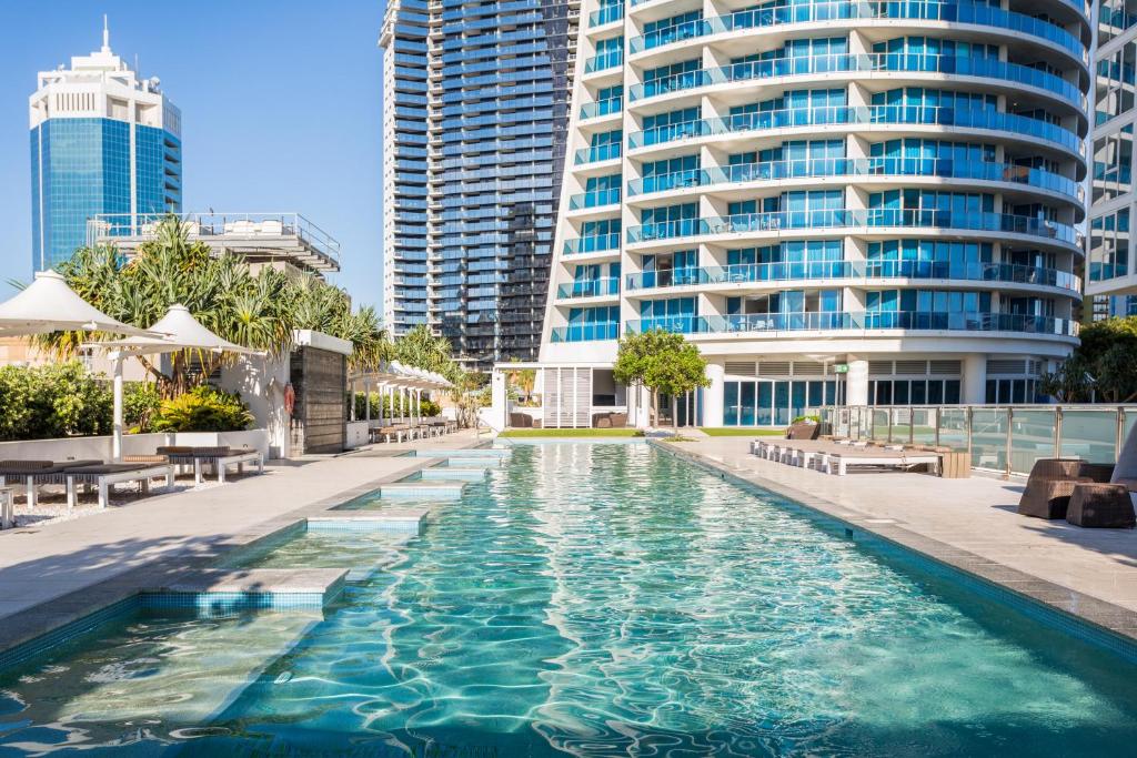 黄金海岸假日H公寓式酒店的一座高楼前的游泳池
