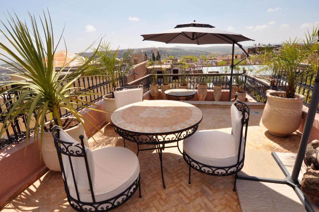 非斯雷拉酒店的庭院配有桌椅和遮阳伞。