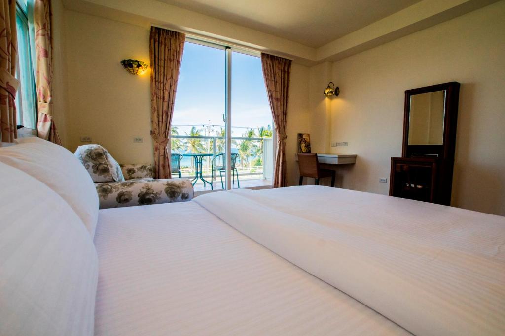 Fushan海水蓝民宿的卧室设有一张白色大床和一扇窗户。