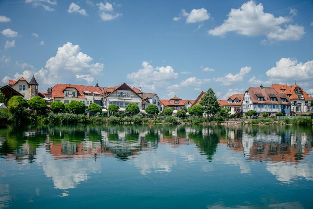 NiedernbergSeehotel Niedernberg - Das Dorf am See的一群房子,靠近水体