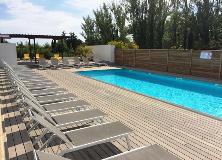 普罗旺斯艾克斯Les Terrasses D'Aix - Studio avec Grande Terrasse privée的一个带躺椅的游泳池,毗邻一个木甲板