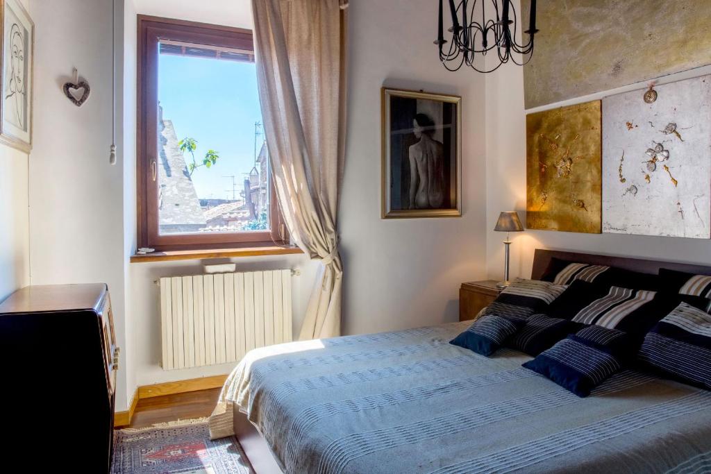 维泰博Antica Dimora San Pellegrino的一间卧室配有一张带蓝色床单的床和一扇窗户。