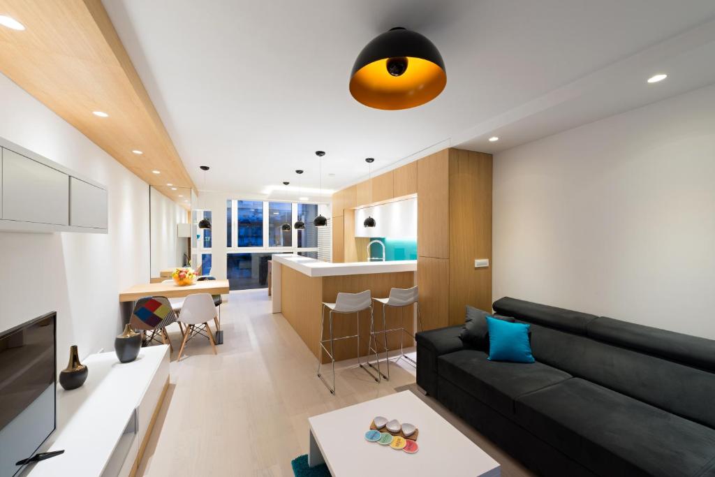 贝尔格莱德Vivio Luxury Apartment的一间带黑色沙发的客厅和一间厨房