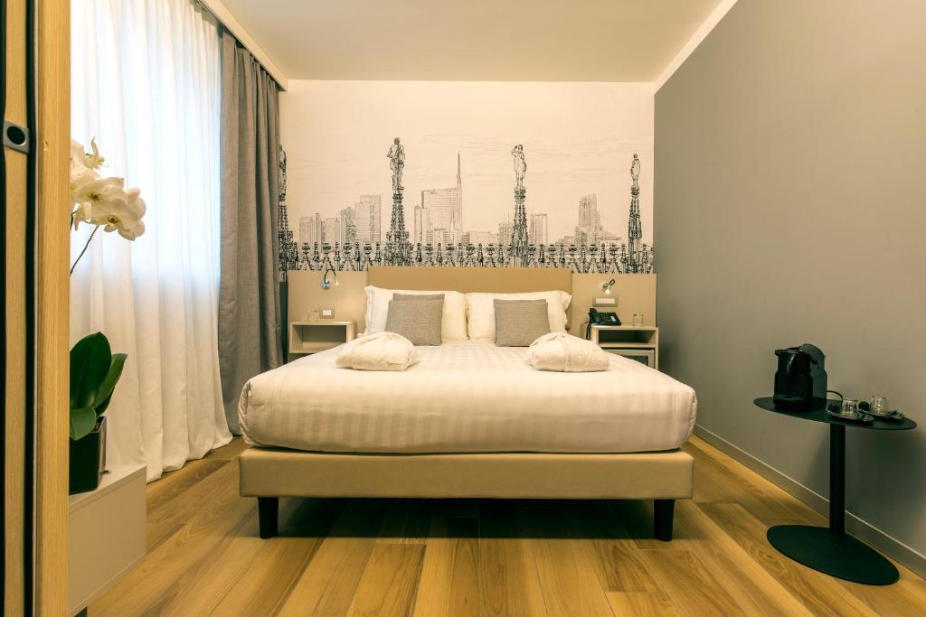 米兰43号车站酒店的一间卧室配有一张带白色床单的大床