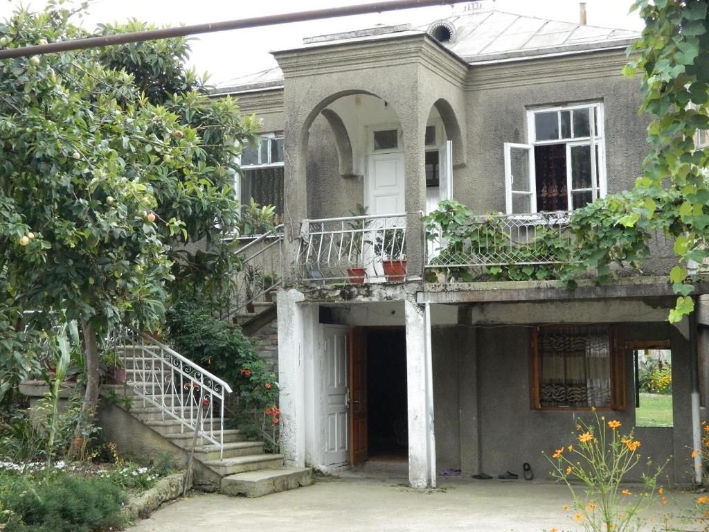 新阿丰Guest house na Myasnikova Diamond的一座带门廊和阳台的古老房屋
