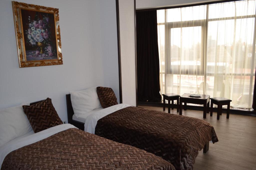 Pecica VecheHotel Taverna Pecicana的酒店客房设有两张床、一张沙发和一个窗口。