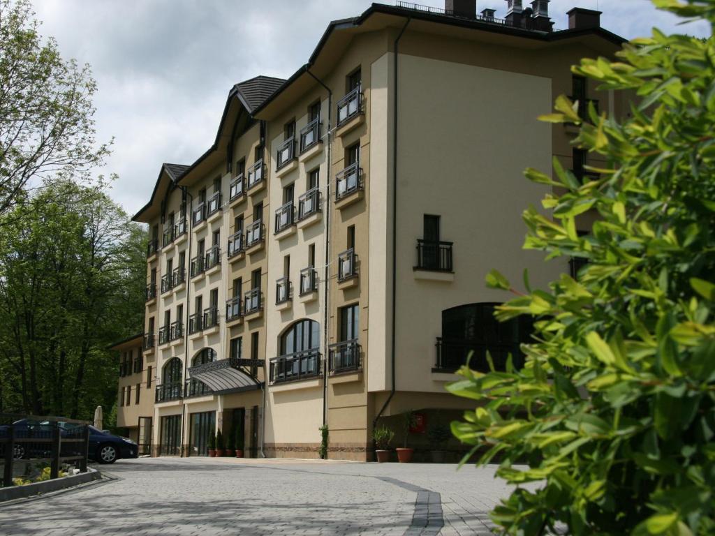 什切尔克厄尔布鲁士温泉疗养酒店的一座白色的大建筑,有很多窗户