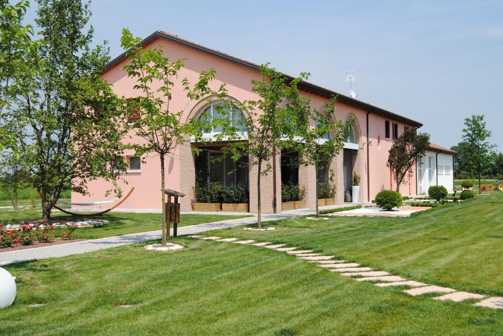法瓦罗威尼托Agriturismo Ca' Beatrice - Venice Airport的粉红色的房子,前面有草坪