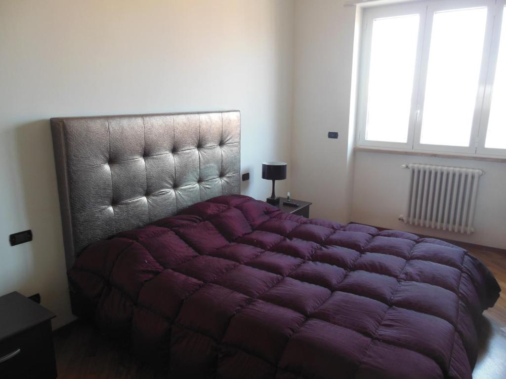 特拉尼La Casa degli Artisti的窗户客房内的大紫色床