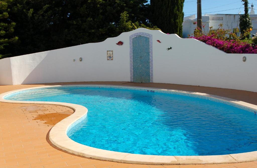 卡武埃鲁Villa Tara Christina的一座铺有瓷砖地板的小型游泳池和一座建筑