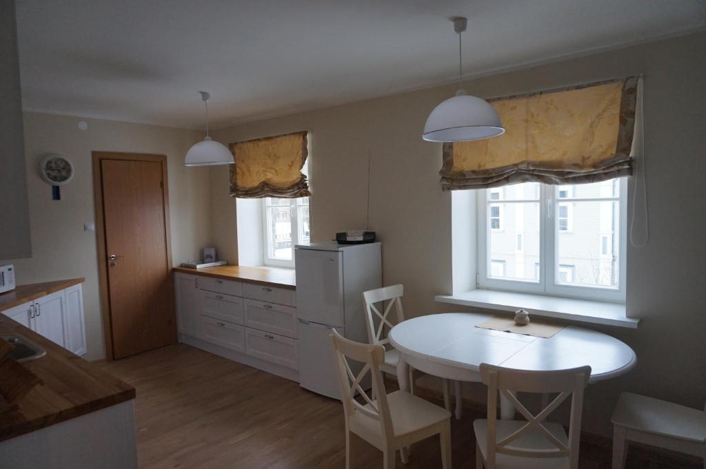 库雷萨雷Pargi Apartment的厨房配有白色的桌椅和2扇窗户。
