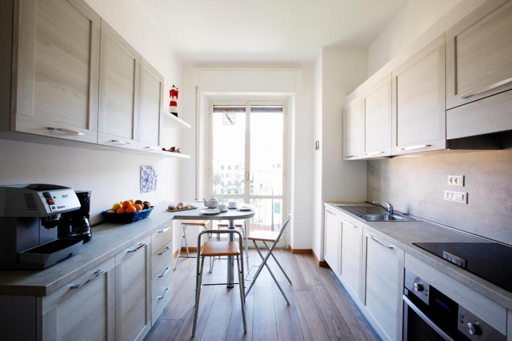 莱万托里维拉公寓的厨房配有白色橱柜和小桌子