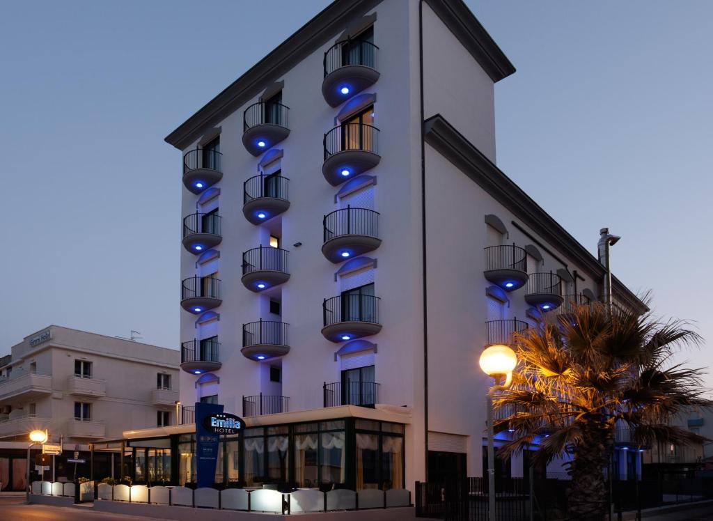 里米尼艾米利亚酒店的建筑的侧面有蓝色的灯光