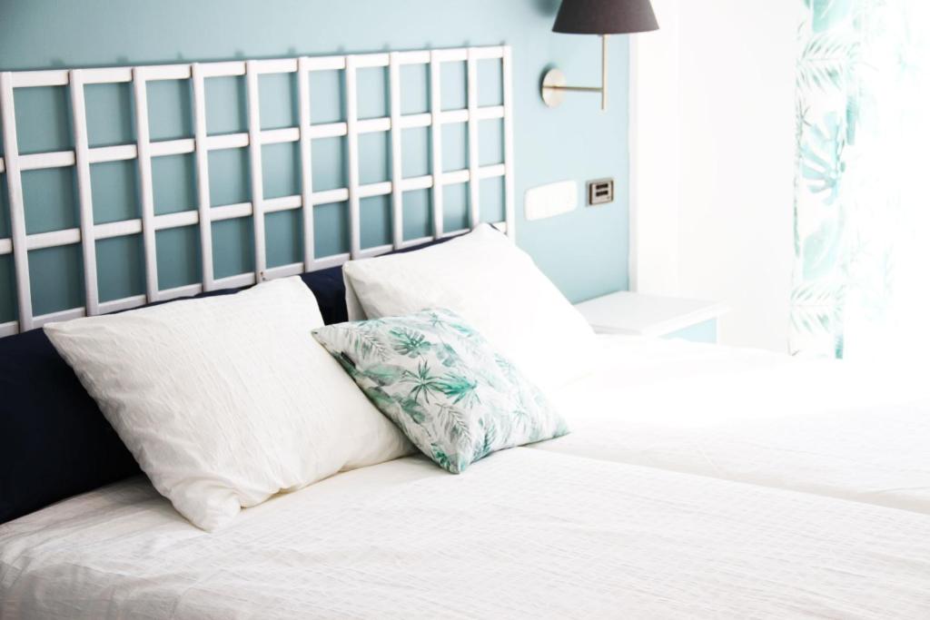 甘迪亚雨果海滩酒店 的一间卧室配有两张带白色枕头的床