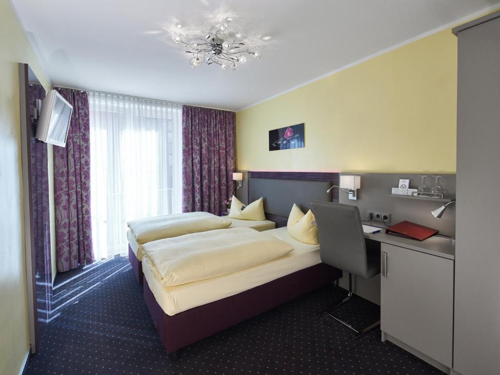 慕尼黑赞图姆阿尔法酒店的配有一张床和一张书桌的酒店客房