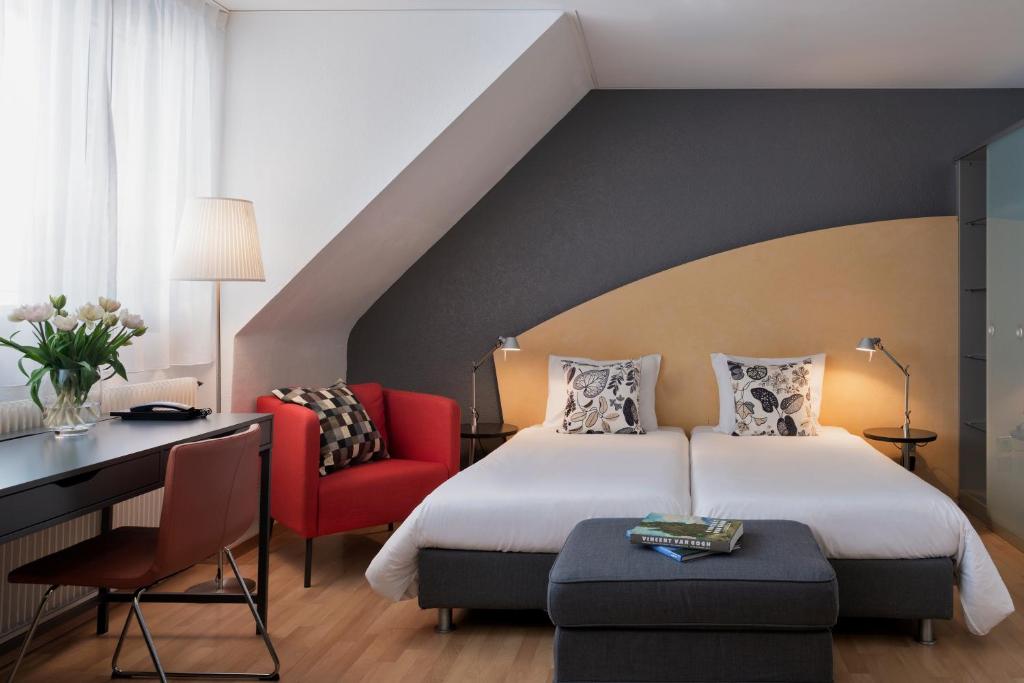 伯尔尼拉裴格拉伯尔尼酒店的一间卧室配有一张床、一张桌子和一把椅子
