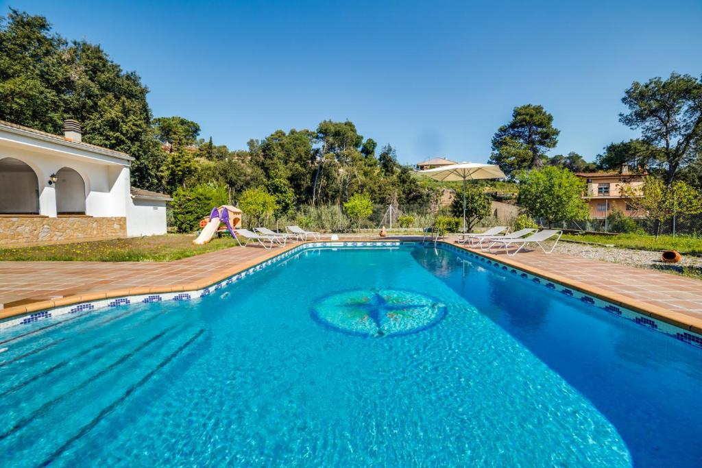 帕拉福尔斯Vivalidays Casa Genis的蓝色海水游泳池和木甲板