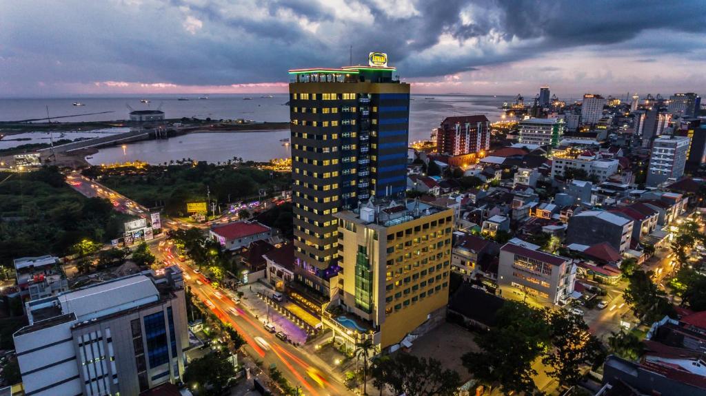 马卡萨Arthama Hotels Makassar的夜晚在城市的高楼