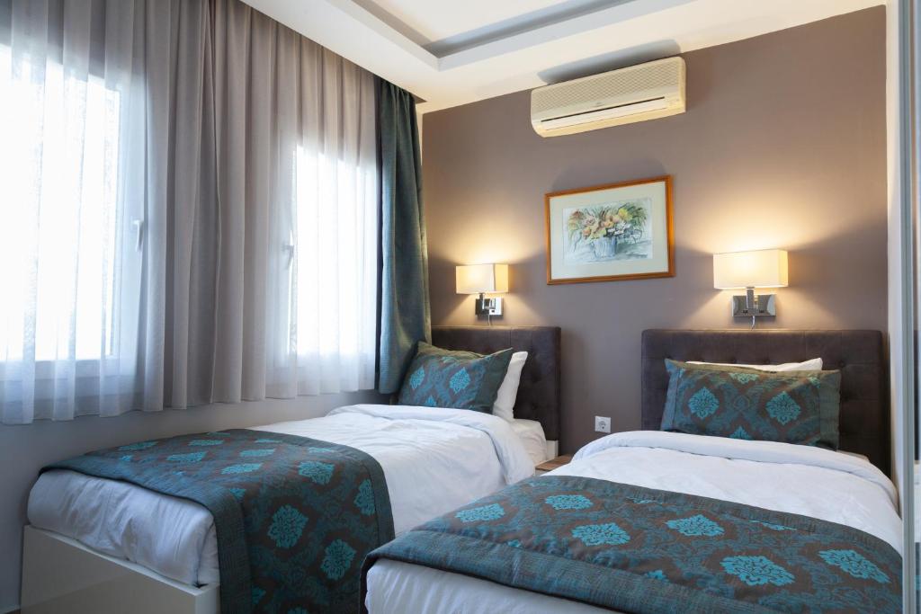 亚力卡瓦克Sun Garden Apart Hotel的酒店客房设有两张床和窗户。