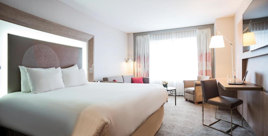 蒙特利尔诺富特蒙特利尔中心酒店的酒店客房设有一张大床和一张书桌。