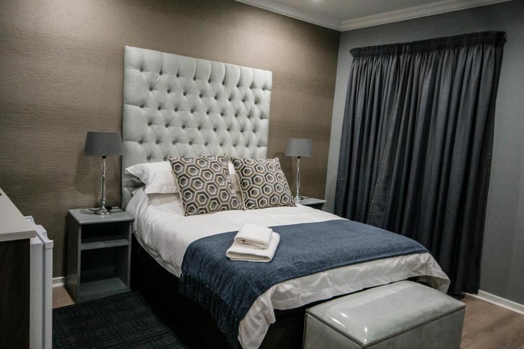 克莱克斯多普The Royal Guest House的一间卧室配有一张大床和大床头板