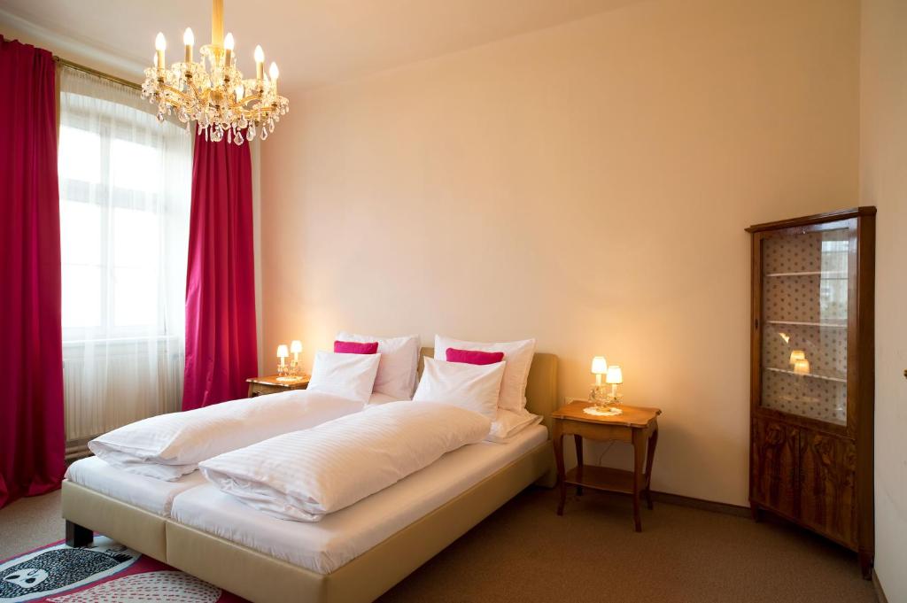 维也纳芬克经济客房旅馆的一间卧室配有一张带红色窗帘和吊灯的床。