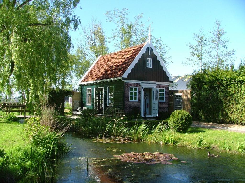 AssendelftB&B Saense huisje的前面有池塘的小房子