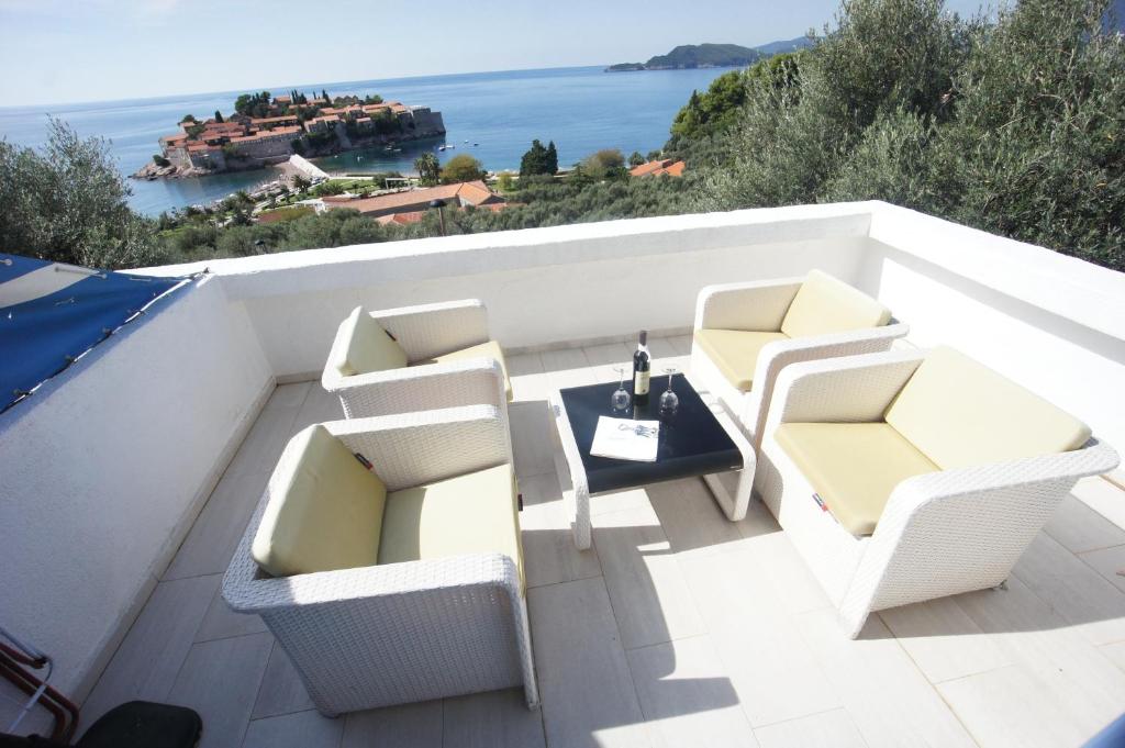 斯韦蒂·斯特凡Vila Mitrovich的阳台配有白色椅子和桌子,享有海景。