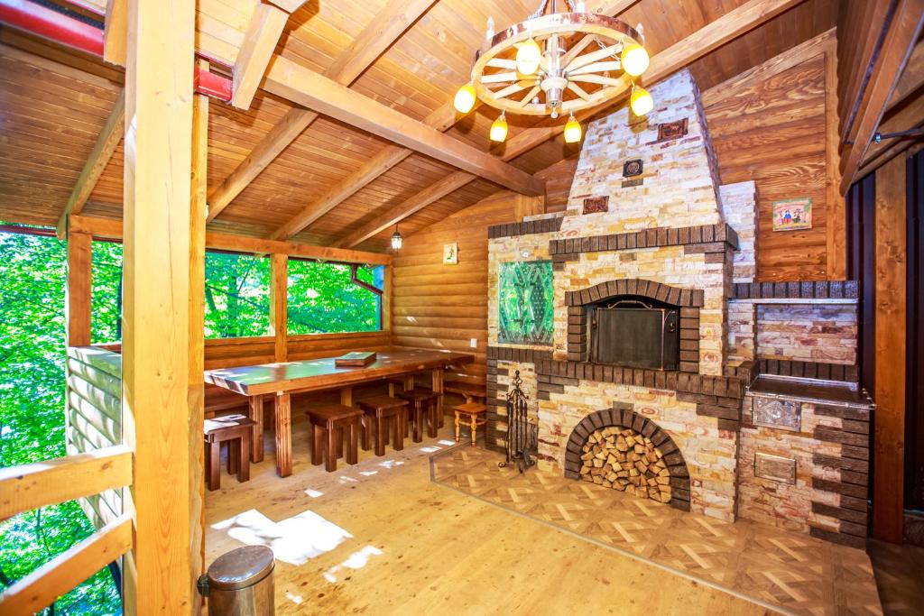 亚列姆切Cottage Berdo的小木屋内带石制壁炉的用餐室