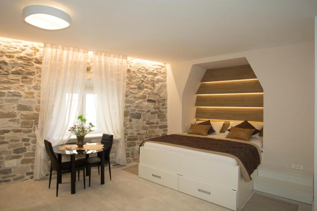 斯普利特Situs Residence的一间卧室配有一张床、一张桌子和一个窗户。