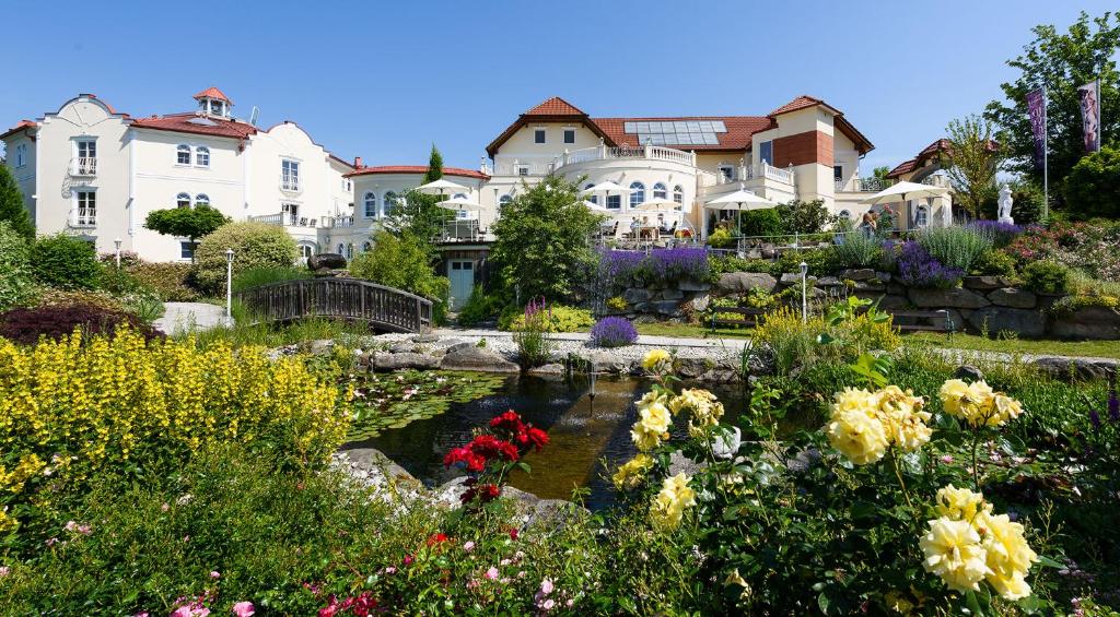 阿芬瑟尔Bergergut Geniesserhotel的一座带池塘的大房子前面的花园