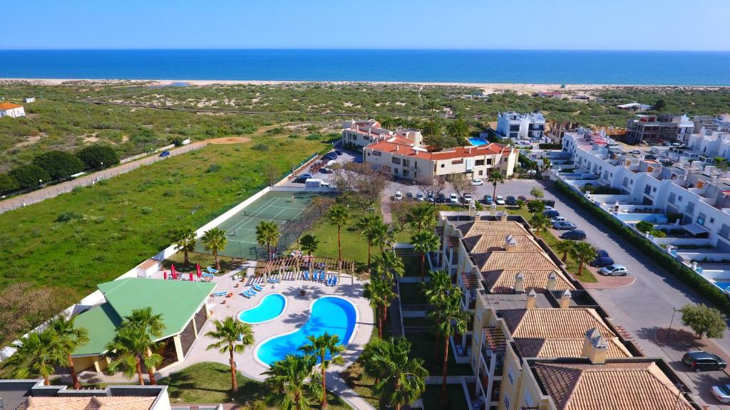 曼塔罗塔Praia da Lota Resort – Beachfront Apartments的享有带游泳池的度假村的空中景致