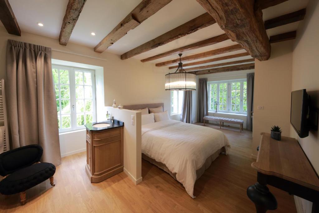 Migné-AuxancesLe Moulin De Nanteuil的一间卧室配有一张床、一张书桌和两个窗户。