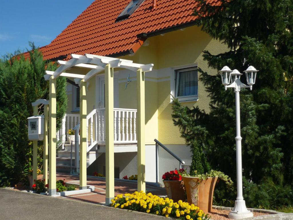 鲁斯特Ferienwohnung Kessler的黄色的房子,设有门廊和街灯