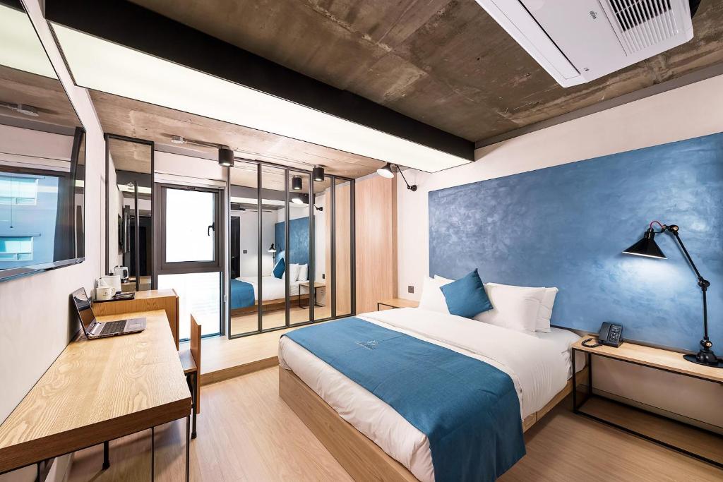 首尔Delight Hotel Jamsil的一间卧室配有一张床、一张桌子和一张书桌