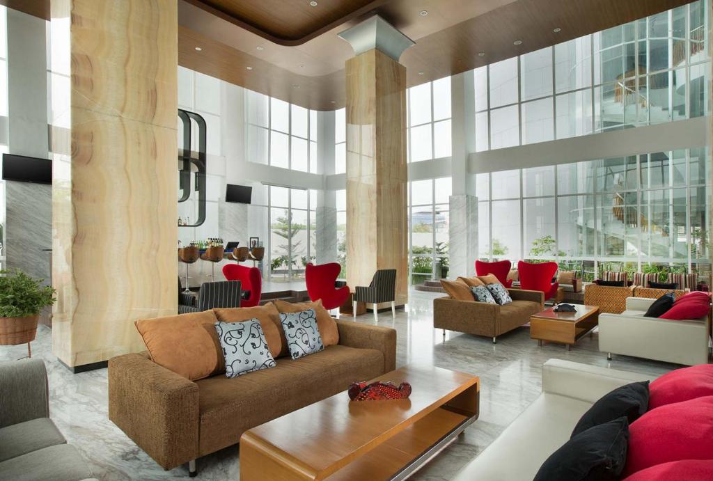 雅加达雅加达布鲁特 - 哈尼瑞斯通套房酒店的大楼内客厅,配有沙发和桌子