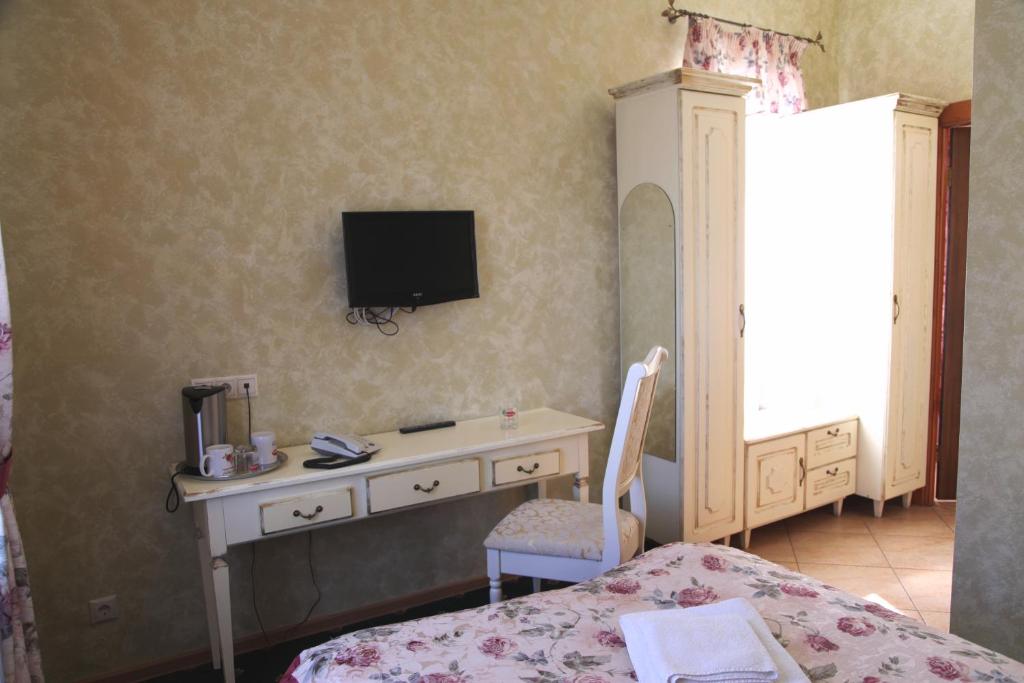 乌法多布尔兹德拉维奇酒店的一间卧室配有一张桌子和一台墙上的电视。