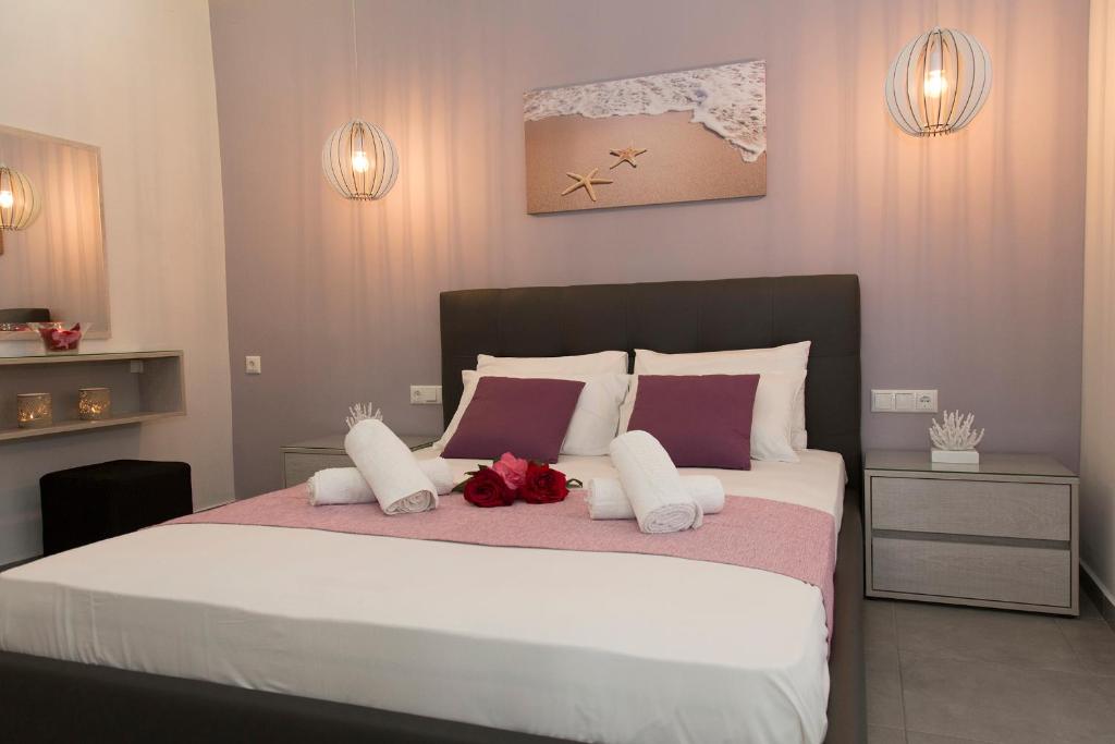 埃亚玛琳娜奈奇多Litinakis Studios的一间卧室配有一张大床,提供紫色和白色枕头