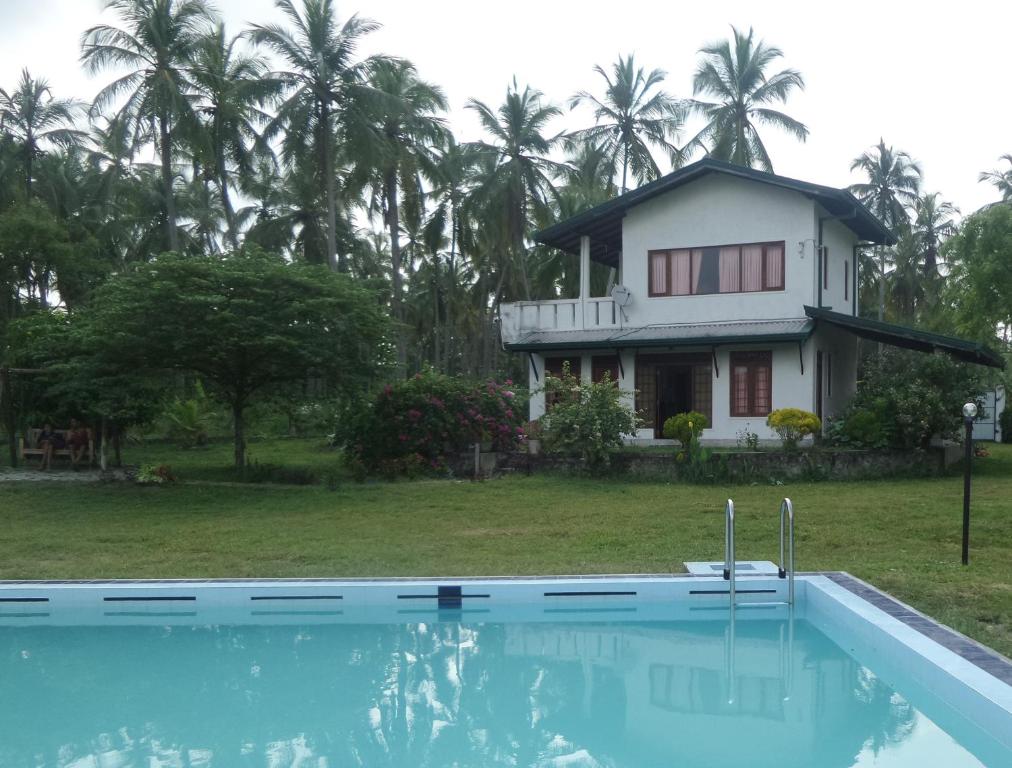 Bandara Koswattacocoworld bungalow的房子前面的房子和游泳池