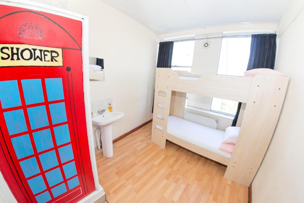 伦敦肯萨尔绿色背包客旅舍 的一间设有红色电话亭和一张双层床的客房