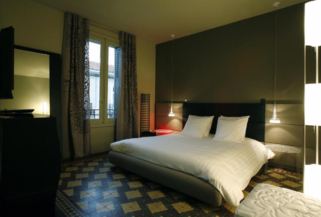 蒙彼利埃Les 4 étoiles的卧室设有一张白色大床和一扇窗户。