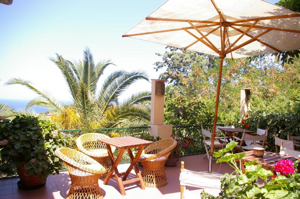 马尔恰纳贝尔特拉蒙托酒店的庭院配有桌椅和遮阳伞。