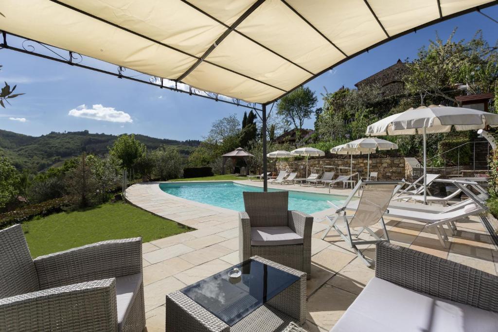 基安蒂格雷夫卡萨莱勒马斯住宿加早餐旅馆的一个带游泳池、椅子和遮阳伞的庭院
