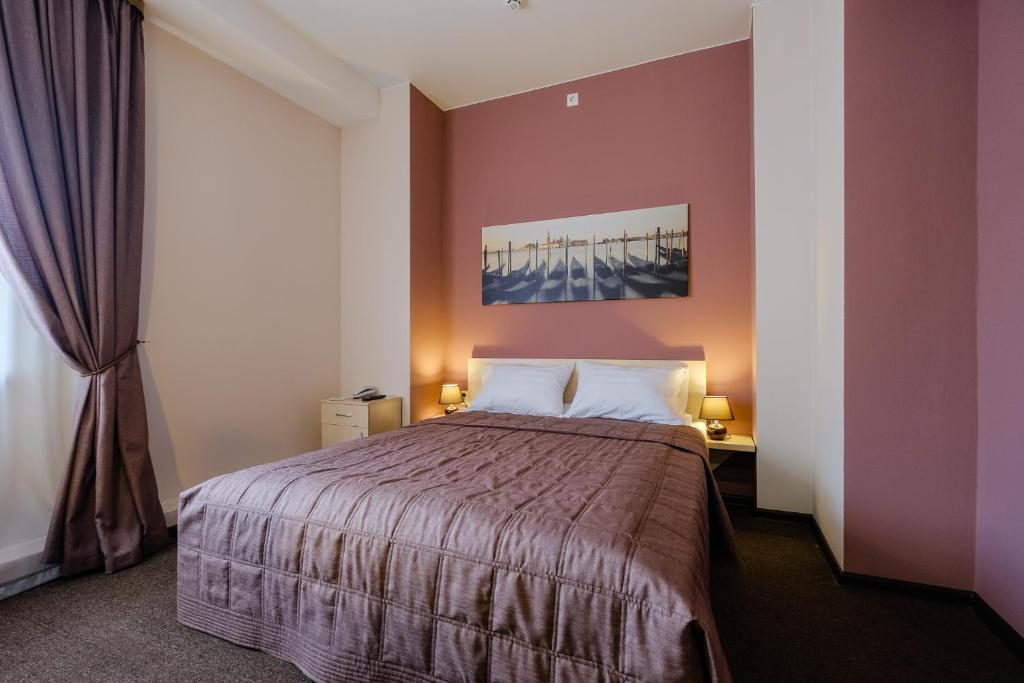 托木斯克Hotel Galereya的一间卧室设有一张紫色墙壁的大床