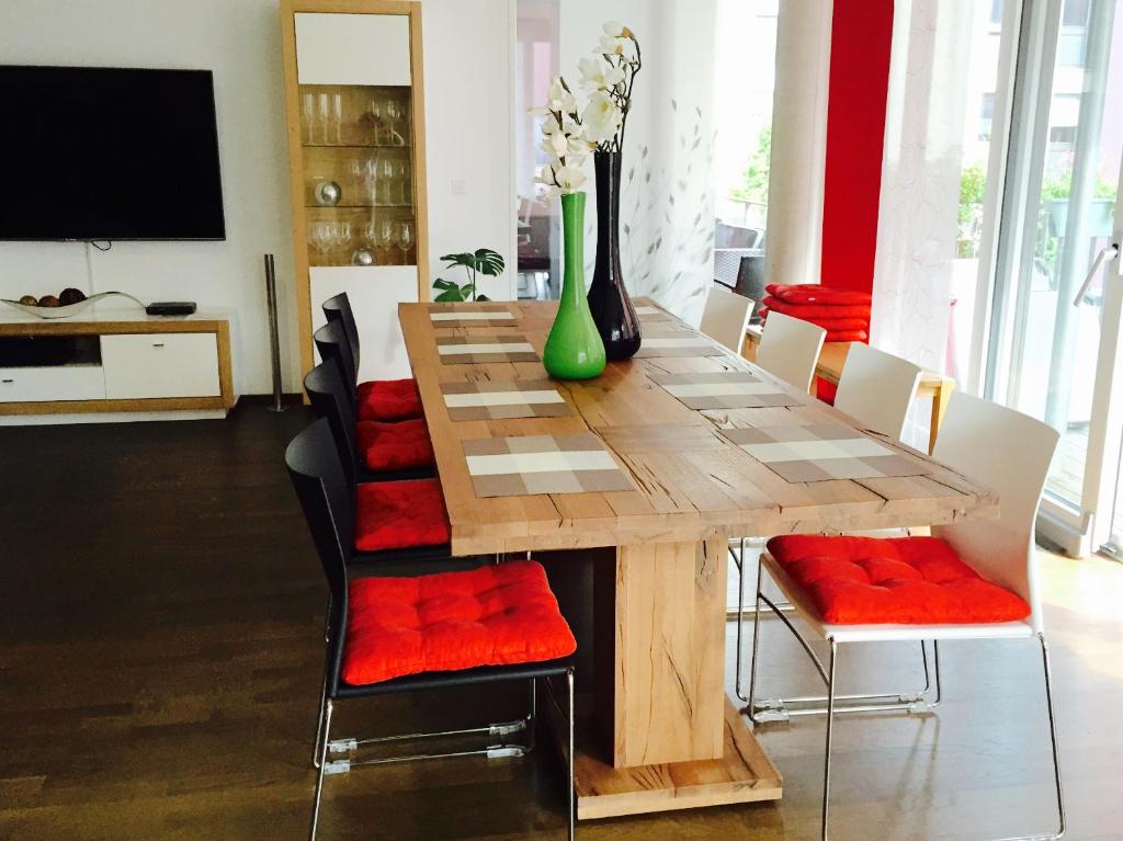 康斯坦茨Rheinblick Riverview Luxury的餐桌、椅子和花瓶