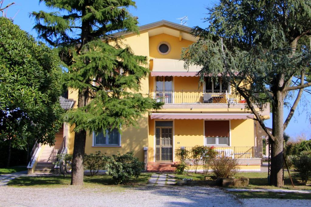 卡瓦利诺Appartamenti Giardino al Mare的前面有树木的黄色房子