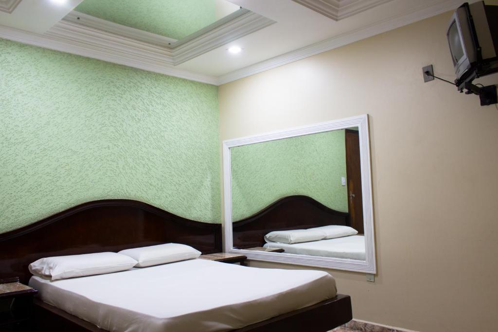 巴西利亚Hotel Valadares的一间卧室配有两张床和镜子