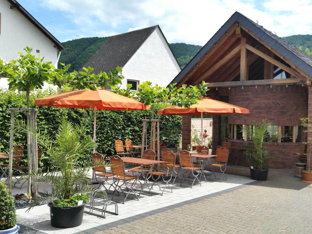特里滕海姆波力格宾馆的一个带桌椅和遮阳伞的庭院